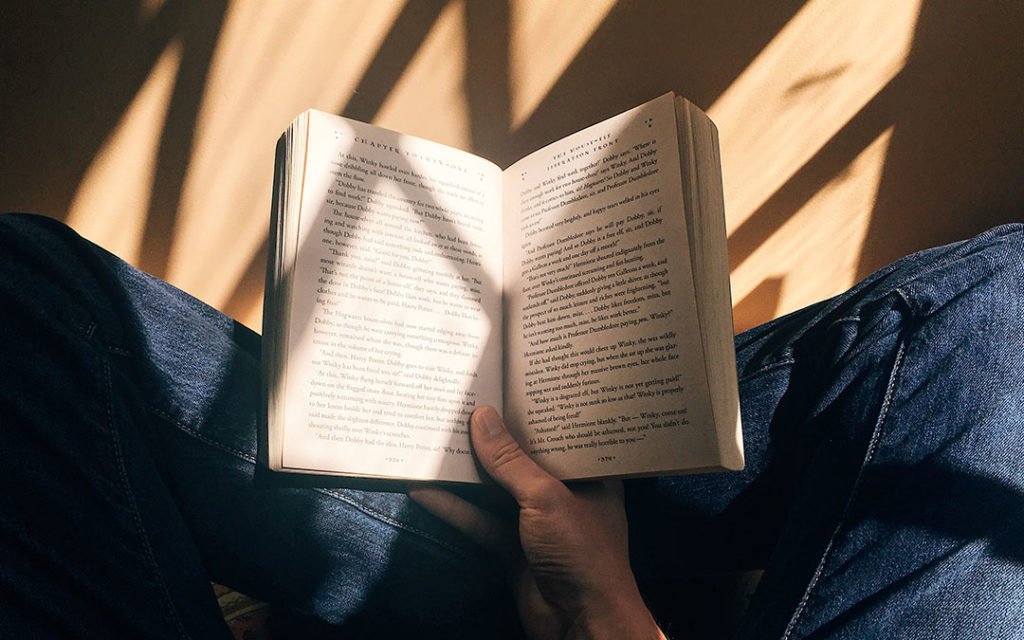 Overhead photo of someone reading a book on the floor